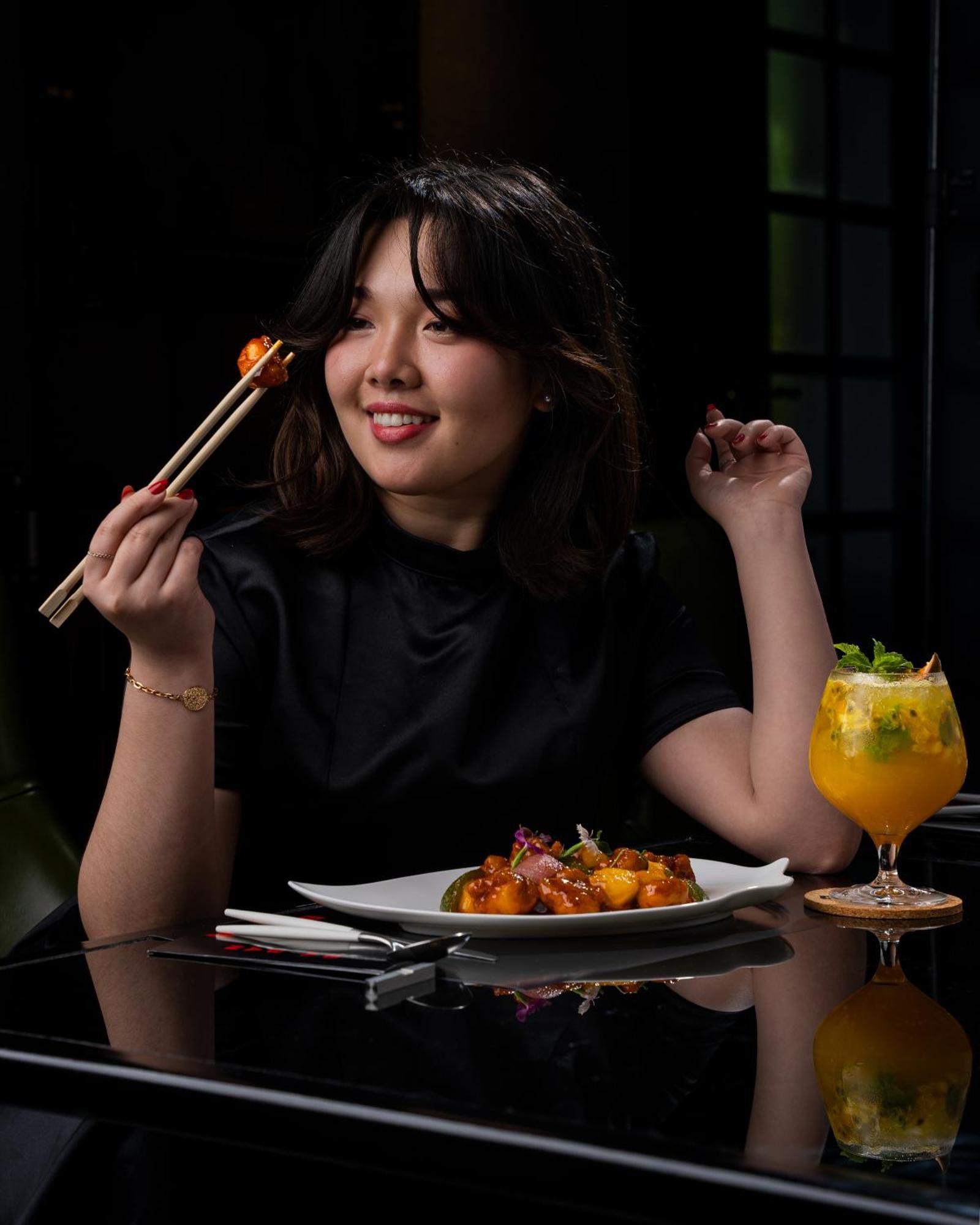 W Muscat Hotel Luaran gambar A woman eating with chopsticks